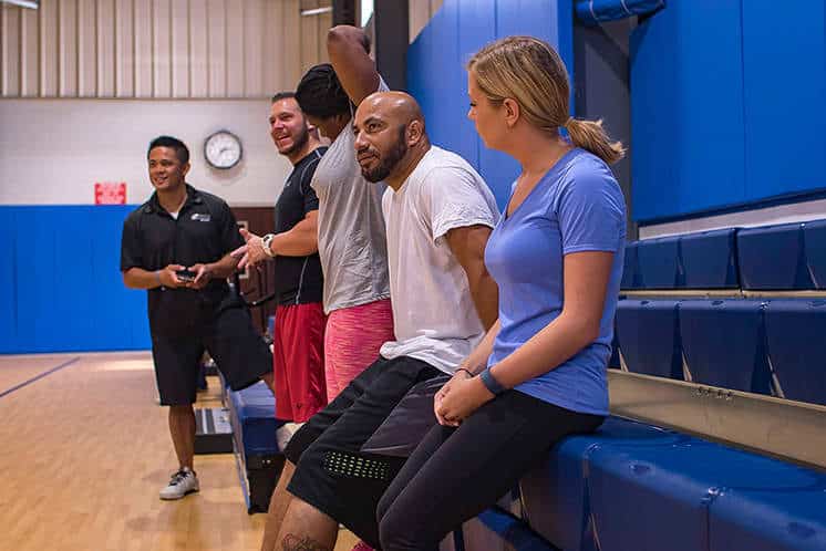People on the sidelines of a gym court